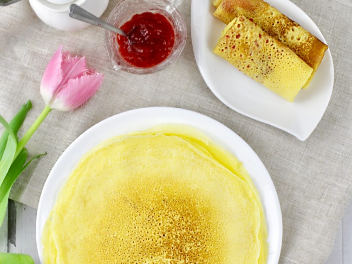 Naleśnik z wytrawnym nadzieniem serowym Gotowy puszysty naleśnik bezglutenowy zwinięty z serem i szpinakiem na talerzu