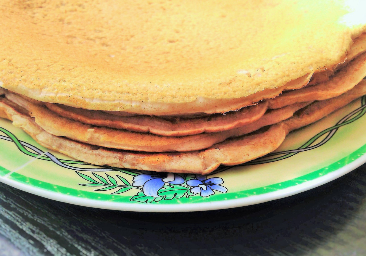 Słodkie naleśniki z bananami i syropem Stos naleśników bezglutenowych polany syropem klonowym z plasterkami bananów