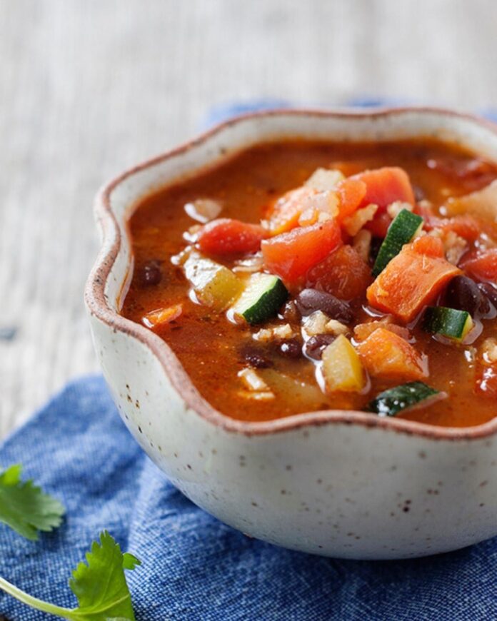 Kolorowe leczo warzywne z papryką cukinią pomidorami i cebulą w głębokiej misce