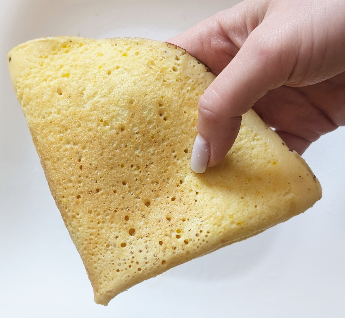 Mieszanie ciasta na puszyste naleśniki Ręce mieszające gładkie ciasto naleśnikowe bezglutenowe w dużej misce drewnianą łyżką